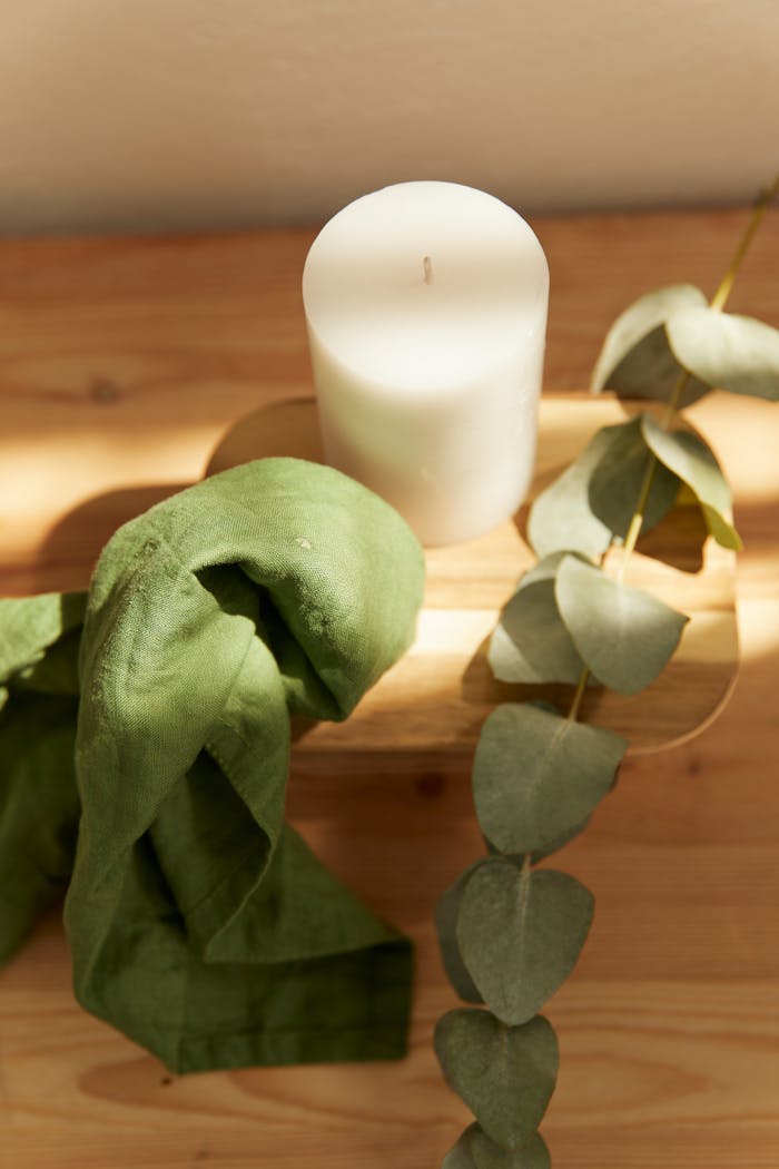 Home Minimalistic setting with eucalyptus and candle, perfect for relaxation.